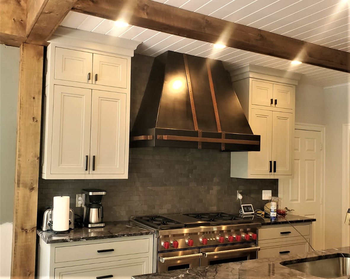 Residential kitchen installation featuring custom range hoods and countertops