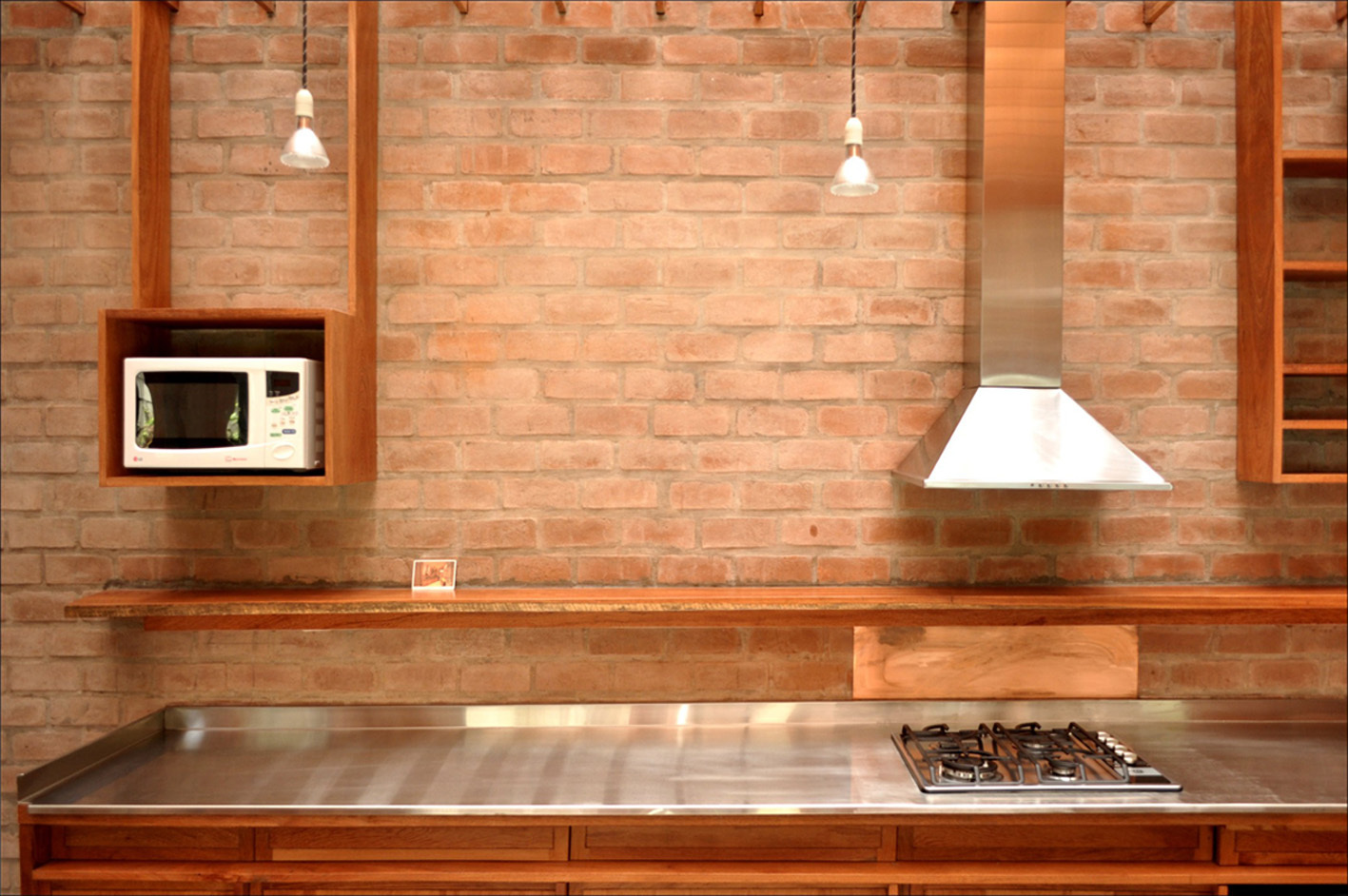 ANBIZA stainless steel countertop with integrated cooktop against an exposed brick wall